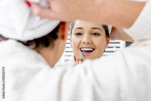 Beautiful woman cleaning her teeth in the bathroom in the morning.