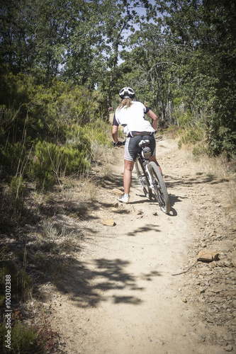 a young woman doing BTT - mountain bicycle riding in the woods