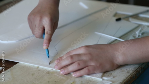 The boy carves model airplane in the aircraft modeling club
