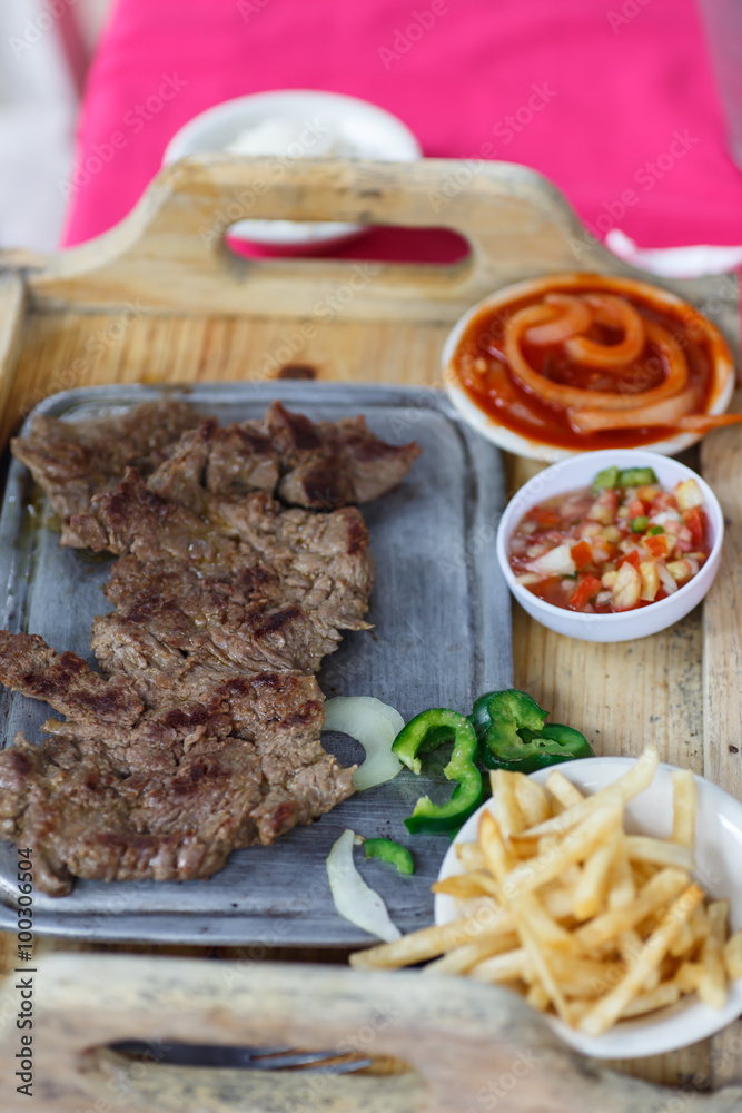 beef steak on table served with potatoes, sauce and vegetables beef steak on table served with potatoes, sauce and vegetables