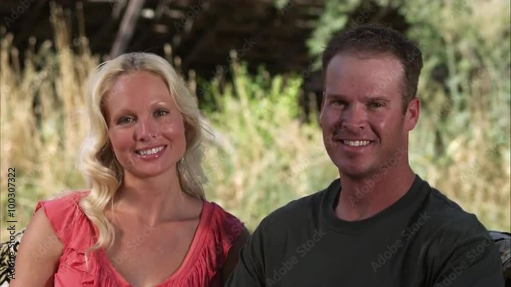 Slow handheld shot of two beautiful people smiling and looking at the camera Slow handheld shot of two beautiful people smiling and looking at the camera