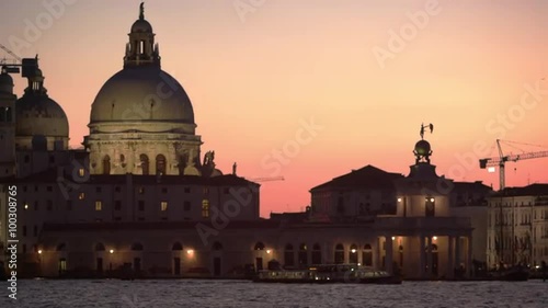 Static shot of Santa Maria della Salute and boats in the canal at sunset. photo