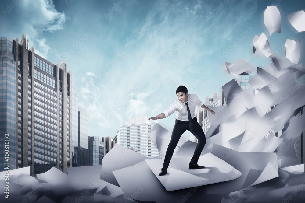 Asian business man surfing on the wave of papers Asian business man surfing on the wave of papers