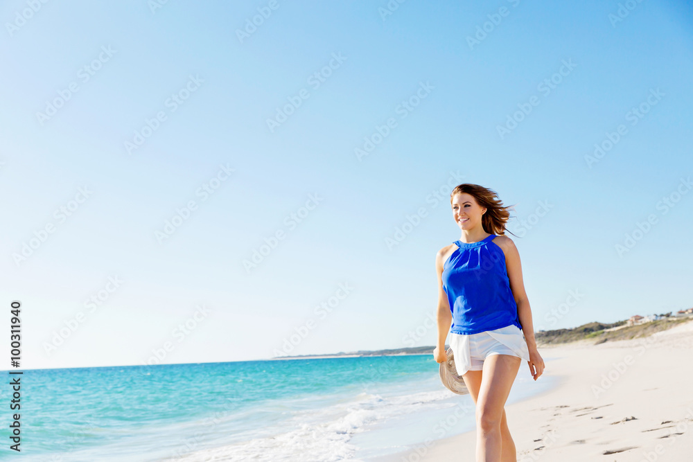 Young woman walking along the beach