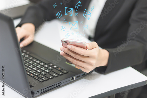 Business woman sitting in front of laptop and mobile phone in hand, working in the office.