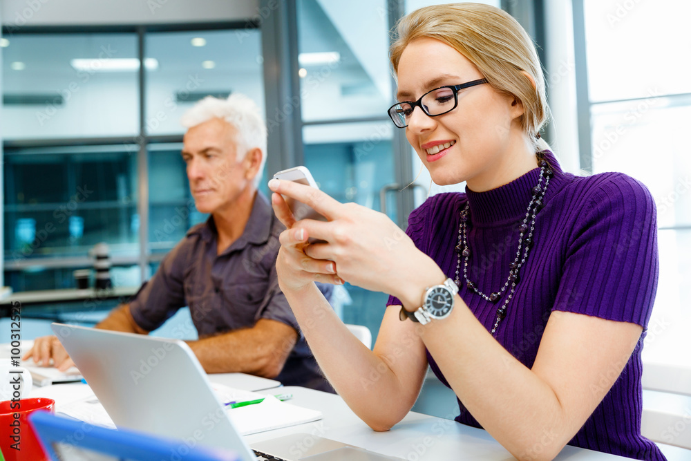 Business woman in office holding mobile phone Business woman in office holding mobile phone
