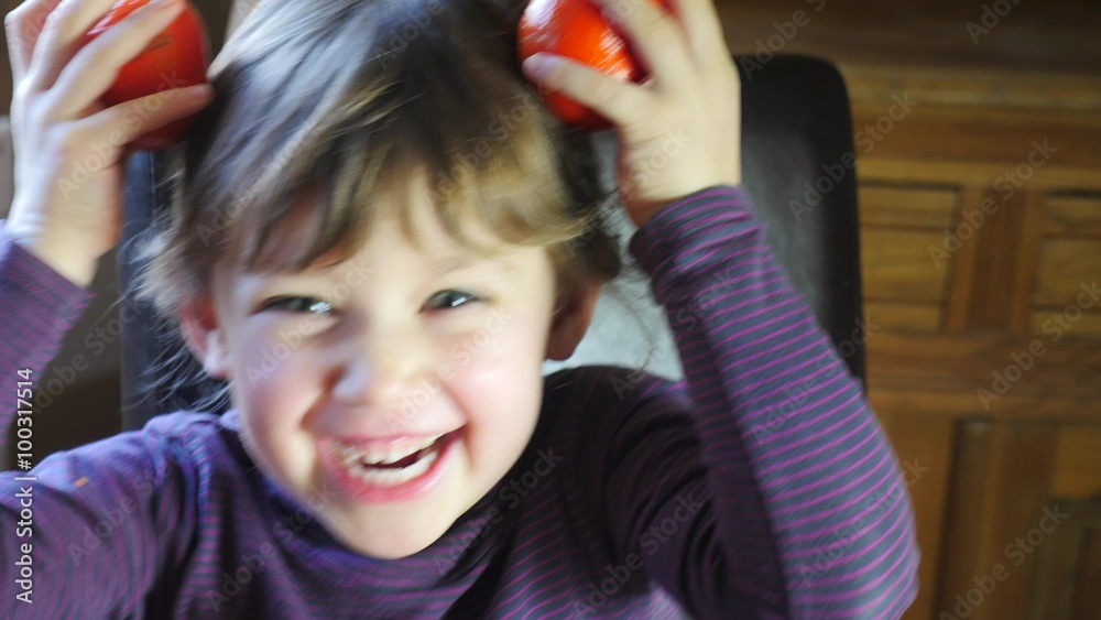 enfant jouant avec des clémentines