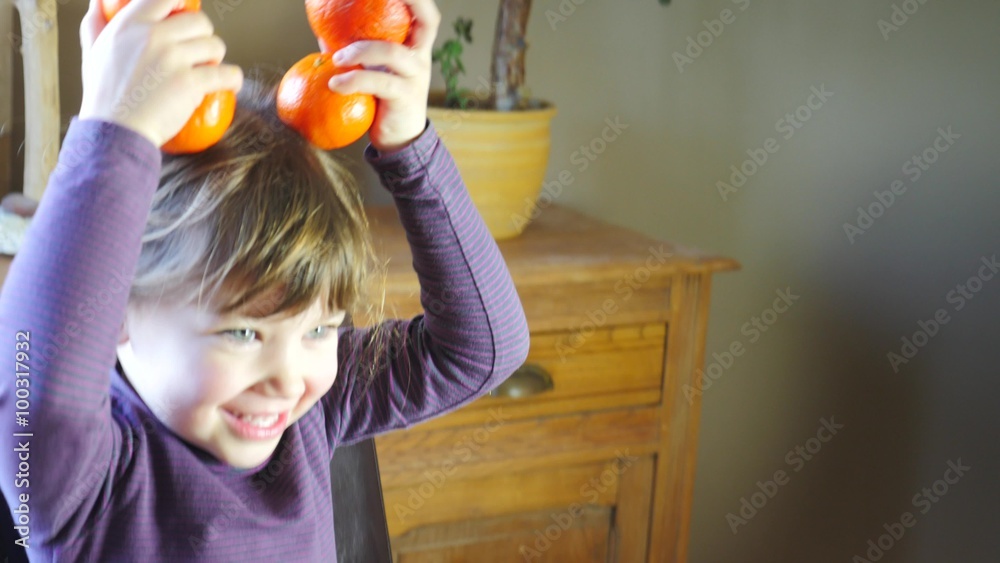 enfant jouant avec des clémentines