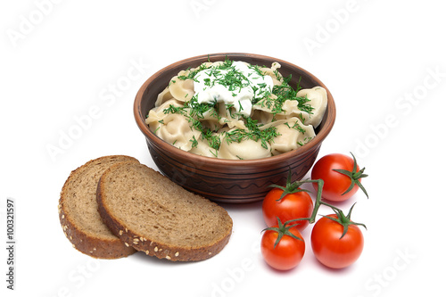 dumplings with sour cream and dill in a bowl on a white backgrou