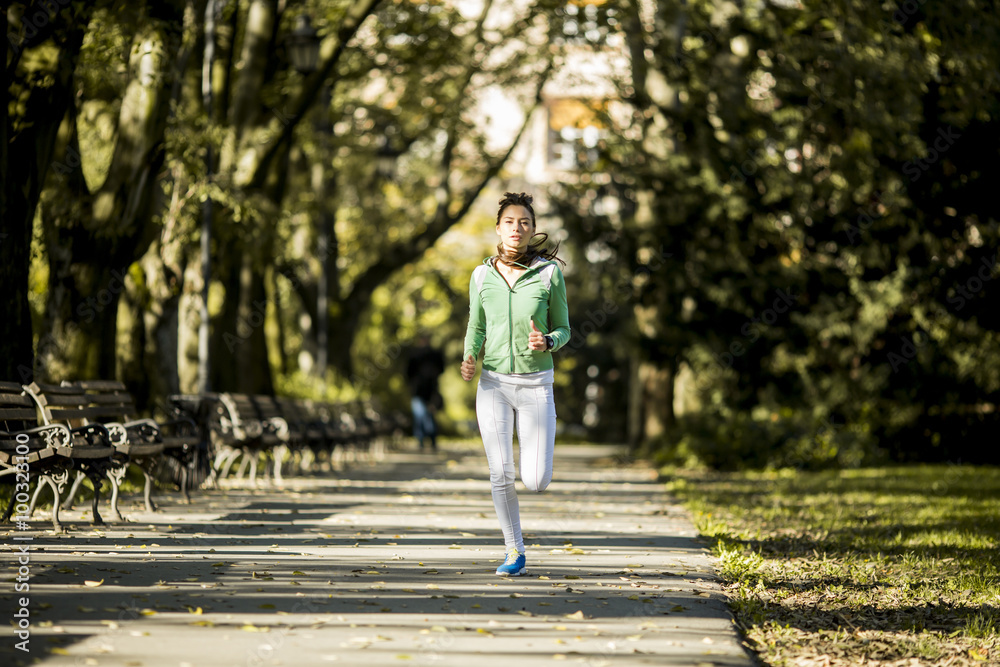 Fototapeta premium Young woman running in the park