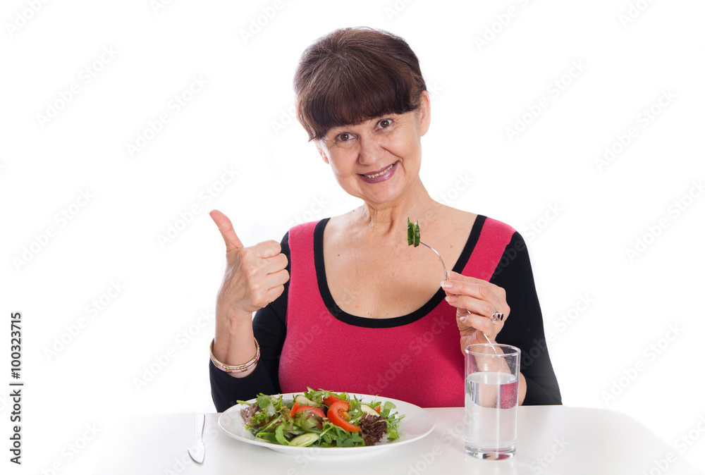 Elderly good looking woman eating green salad. Healthy life style concept Elderly good looking woman eating green salad. Healthy life style concept