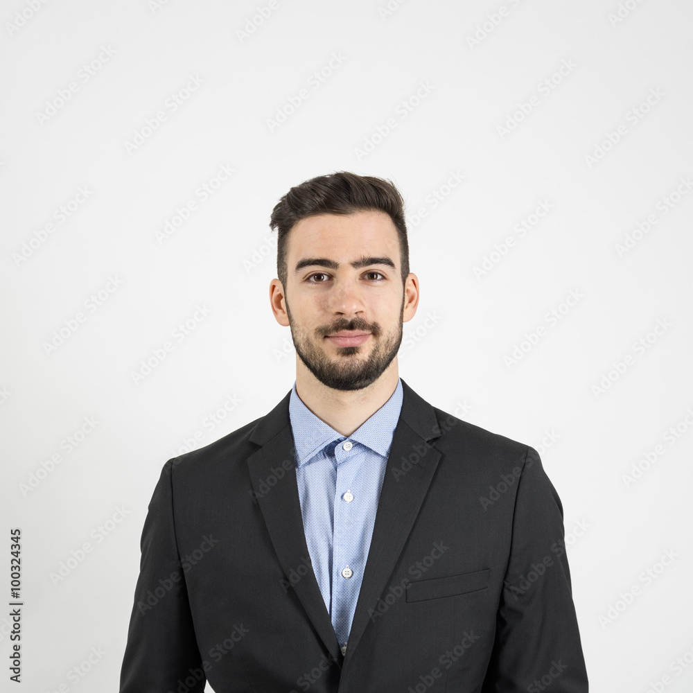 Head and shoulder front portrait of young man in suit and blue shirt looking at camera. Portrait over gray studio background Head and shoulder front portrait of young man in suit and blue shirt looking at camera. Portrait over gray studio background