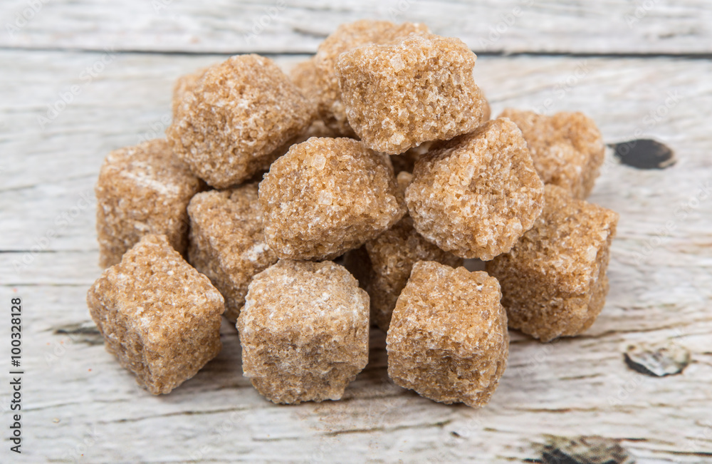 Brown sugarcane sugar cube over wooden background Brown sugarcane sugar cube over wooden background
