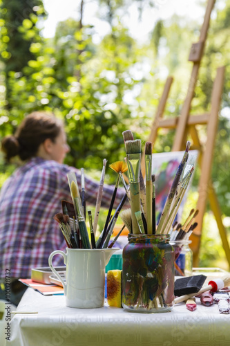 Frau beim Malen mit Pinseln, woman painting with paint brush