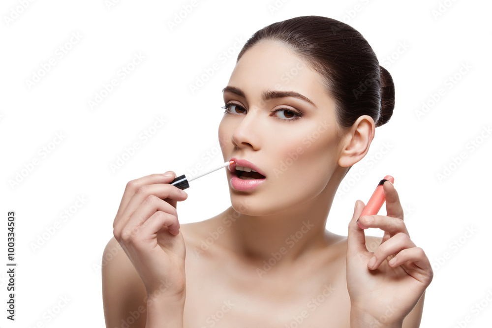 Beautiful girl applying lipgloss