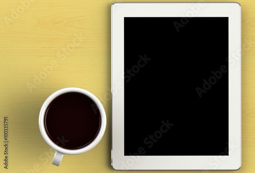 Coffee cup with tablet on yellow wood table