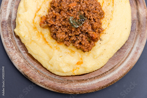 A close up view of a traditional italian dish: Polenta with bolognese soup (ragu)