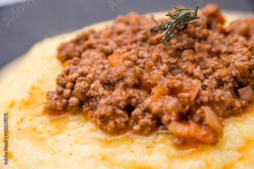 A close up view of a traditional italian dish: Polenta with bolognese soup (ragu)