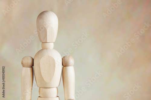 Wooden puppet against brown background