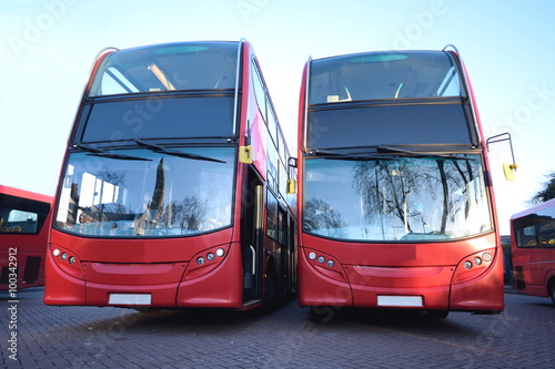 Red double decker buses parked at station photo