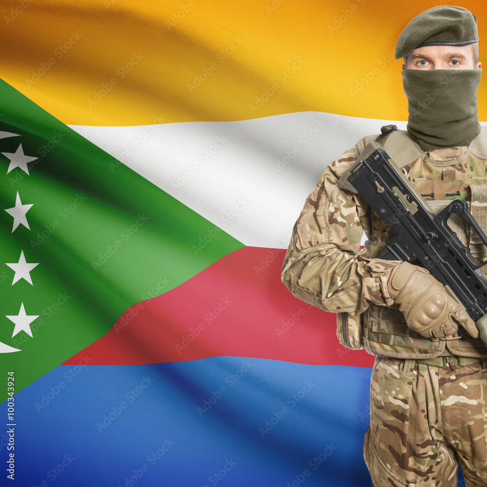 Fototapeta premium Soldier with machine gun and flag on background - Comoros