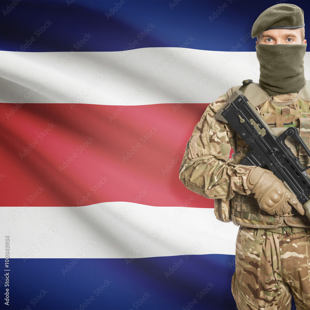 Fototapeta premium Soldier with machine gun and flag on background - Costa Rica