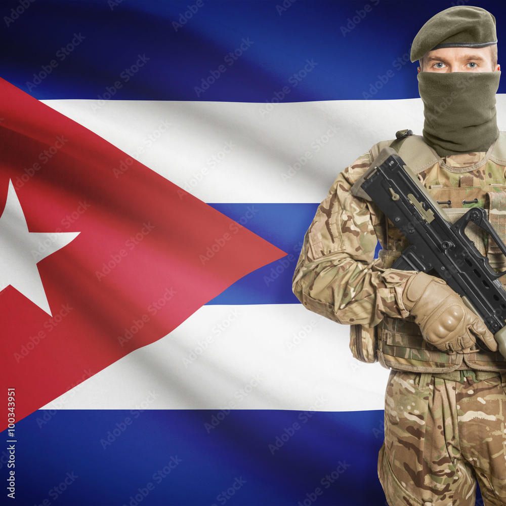 Fototapeta premium Soldier with machine gun and flag on background - Cuba