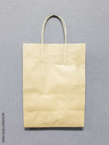 Used Blank Recycle Brown Paper Bag with Copy Space to input Text on Gray Abstract Fabric Background Texture