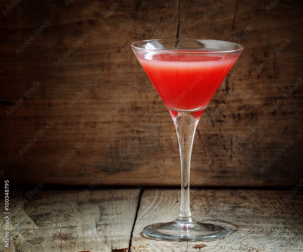 Red margarita cocktail in glass on old wooden background, dark t