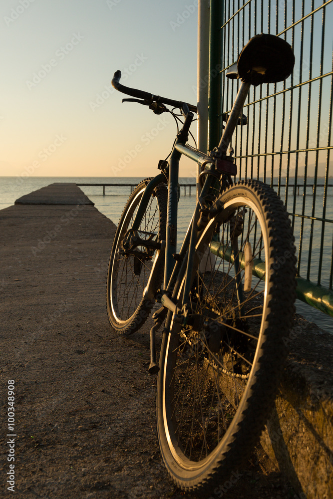 Fototapeta premium bicycle parked on a pier on Lake Iznik, Turkey at sunset