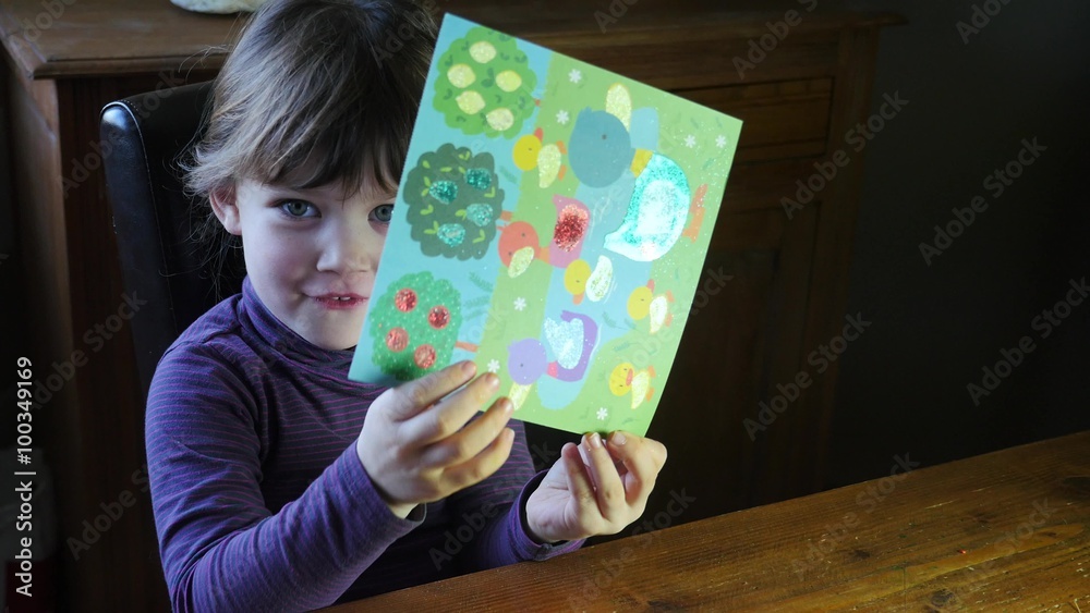 fille montrant son coloriage à paillettes