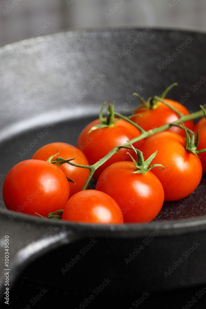 Frying tomatoes cast iron pan / Frying cherry tomatoes in a cast iron frying pan Frying tomatoes cast iron pan / Frying cherry tomatoes in a cast iron frying pan