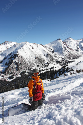 girl snowboarder standing on her knees on the slope