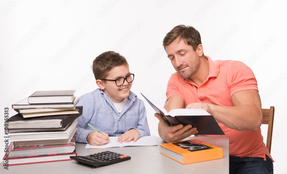 Boy doing homework together with his father