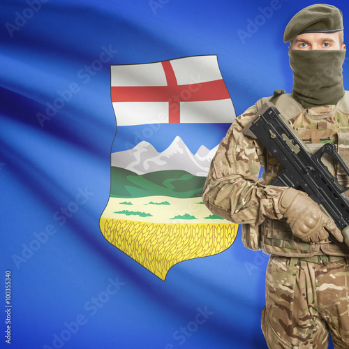 Soldier with machine gun and Canadian province flag on background series - Alberta