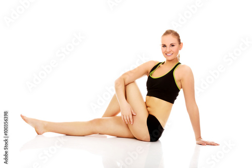 Young woman doing stretching exercise on the floor