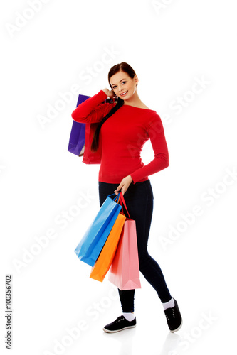 Young happy smiling woman holding shopping bags