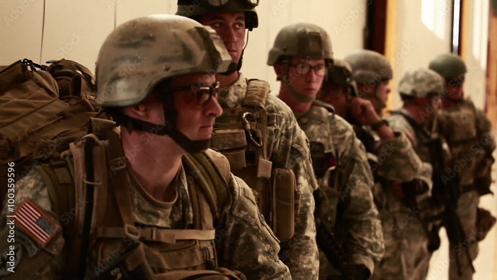 Soldiers with gear standing in line at a hangar. Soldiers with gear standing in line at a hangar.