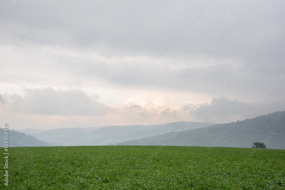 Obraz premium Sunset and mist on one of the hills between mountains