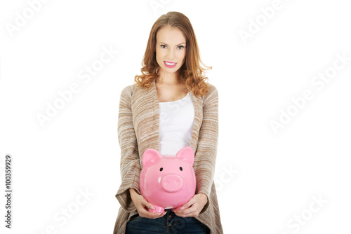 Casual woman holding piggy-bank.