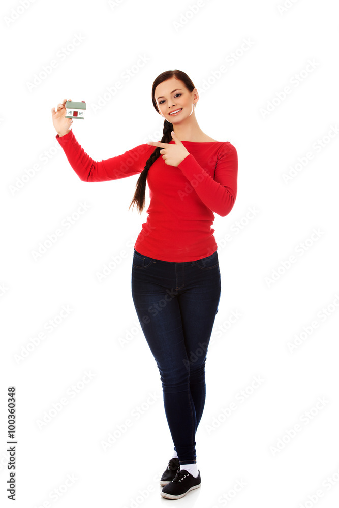 Smiling young woman holding house model Smiling young woman holding house model