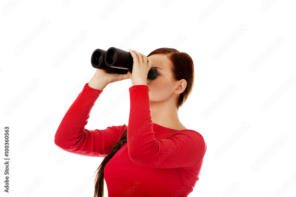 Young woman looking through a binocular Young woman looking through a binocular