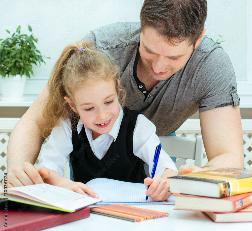 Father helping daughter with homework at home. Father helping daughter with homework at home.