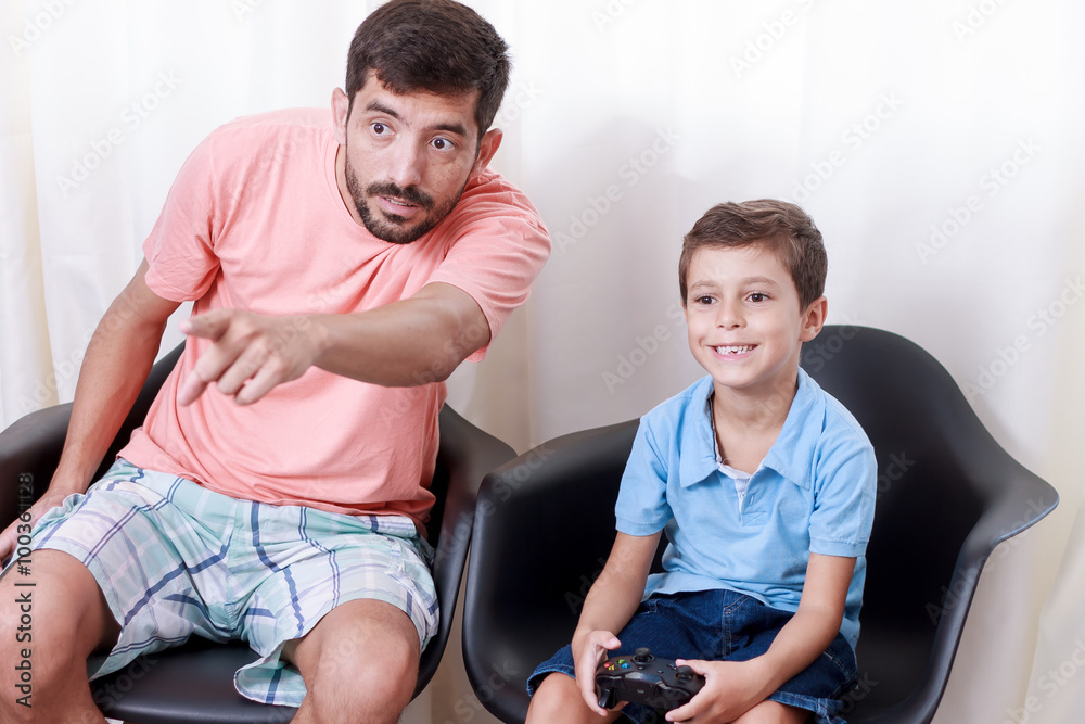 Obraz premium Father and son playing video game in the living room