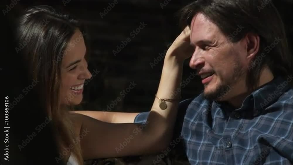 Slow tracking shot of a couple talking and sitting on a couch in the middle of a forest clearing Slow tracking shot of a couple talking and sitting on a couch in the middle of a forest clearing