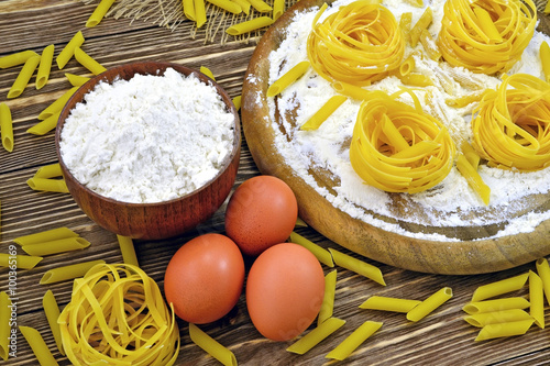 Photo pasta flour and eggs lie on a wooden table for cooking