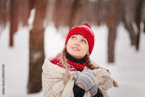 Young woman in winter forest covered with a blanket