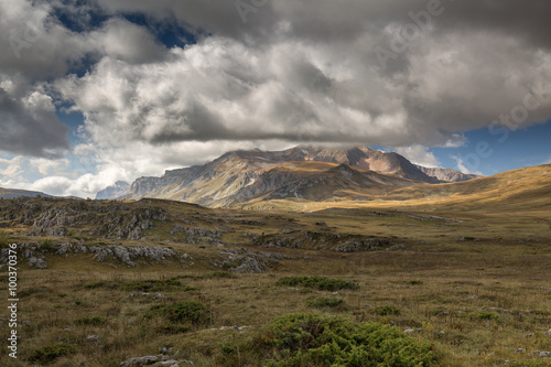 Autumn blue sky with white clouds and mountains on the yellowed