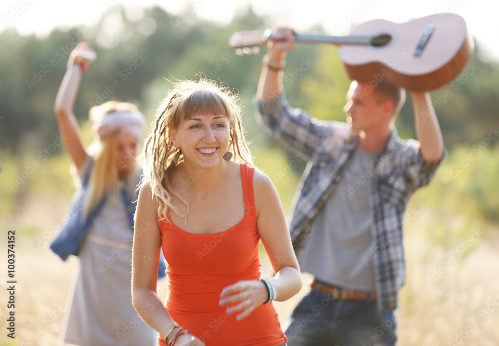 Obraz premium Carefree friends with guitars have fun, outdoors