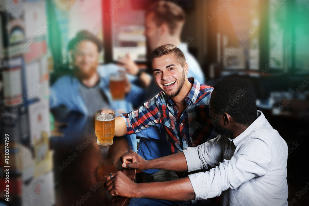 Young men drinking beer in pub Young men drinking beer in pub